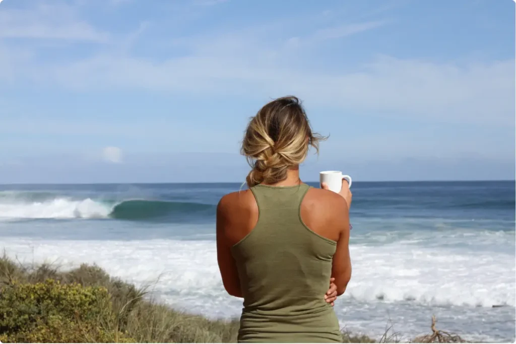 Woman overlooking the ocean at a luxury residential addiction treatment center during recovery