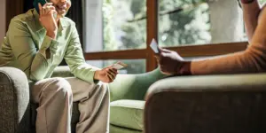 A person holding an insurance card while speaking on the phone about rehab coverage